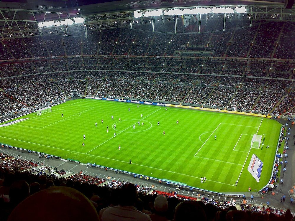Photographie : un stade de football rempli de spectateurs, vu depuis les gradins